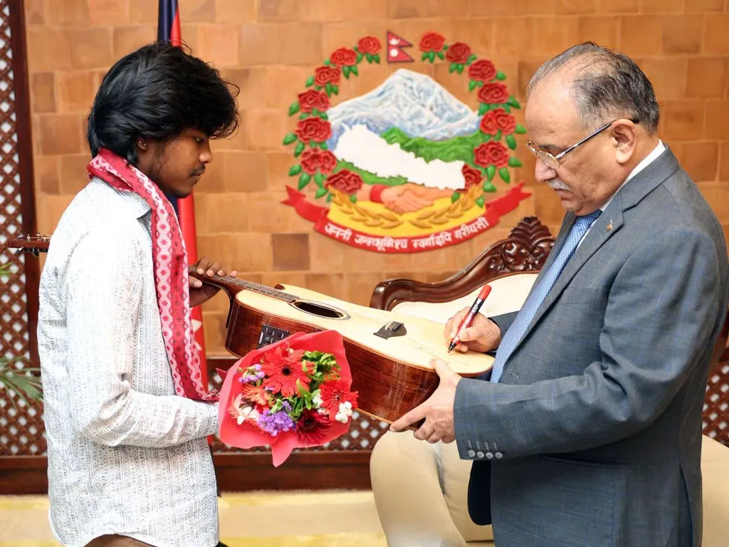 नेपाल आइडलका टाइटल विजेता करणलाई प्रधानमन्त्रीले दिए गितार उपहार